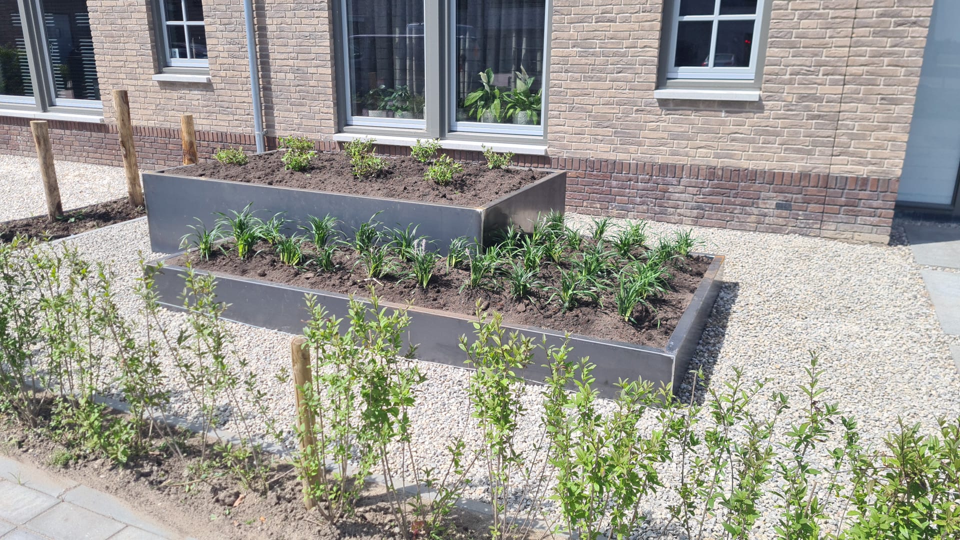 Plantenbakken van cortenstaal in voortuin